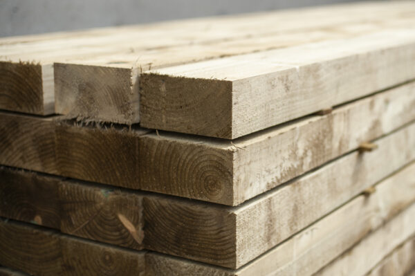Stacked timber sleepers with clean cut ends ready for landscaping or garden edging