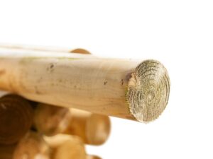 Close-up of stacked round timber jump poles with smooth treated finish