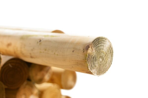 Close-up of stacked round timber jump poles with smooth treated finish